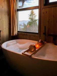 トリシルにあるOriginal Trybo Cabin At Trysil Mountainのキャンドル付きのバスタブ、窓が備わります。