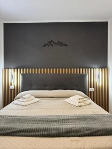a bedroom with a large bed with two towels on it at Cima Bianca Suite in Passo del Tonale