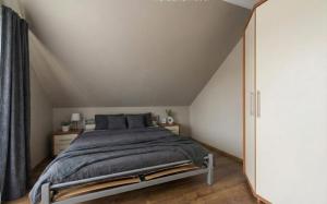 een slaapkamer met een groot bed op zolder bij Sunny Tides in Mielno