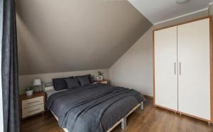 een slaapkamer met een bed en een witte kast bij Sunny Tides in Mielno
