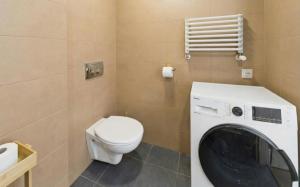 een badkamer met toilet en wasmachine bij Sunny Tides in Mielno