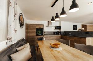 a kitchen and dining room with a wooden table and chairs at Sandi`s Ferienhaus in Reutte