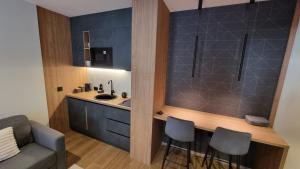 cocina con fregadero y encimera con taburetes en Apartman LUX Tarski san, en Kaludjerske Bare