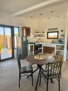 El NaranjoSecret Garden Cottage的房间里有一张桌子和几把椅子的厨房