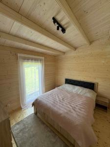 a bedroom with a bed in a room with a window at Poilsio Pieva in Ąžuolų Būda +20 photos