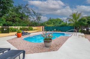 a swimming pool in a yard with chairs and a fence at Nos Yemaya, 2BR, Pool, walking distance from Playa Lagun in Lagun