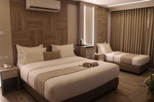 a hotel room with two beds and a window at ALENA HOTEL in Aqaba