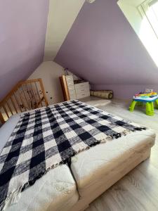 a bedroom with a checkered bed in a attic at Dom pre hostí blízko centra BB in Banská Bystrica