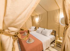 a bedroom with two beds in a tent at Erg Chebbi Dunes Desert Camp in Merzouga