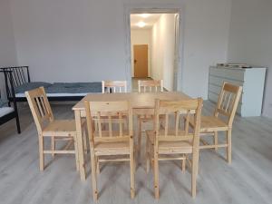 uma mesa de jantar de madeira com cadeiras e uma cama em Apartmány MARTIN SARVAŠ 4 em Tachov