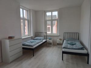 duas camas em um quarto com duas janelas em Apartmány MARTIN SARVAŠ 4 em Tachov