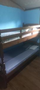 a bunk bed in a room with a blue wall at De la rosa y el canto de los pájaros in Paraty +19 photos
