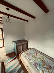 a bedroom with a bed and a dresser at Dobál vendégház in Lunca de Sus