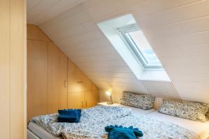 Schlafzimmer im Dachgeschoss mit 2 Betten und einem Dachfenster in der Unterkunft Meeresfeeling in Horumersiel in Horumersiel