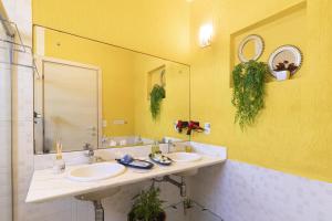 a bathroom with two sinks and a large mirror at Villa Araçà - Boutique Hotel in Lauro de Freitas