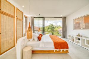 a bedroom with a large bed and a balcony at Senada Garden in Uluwatu
