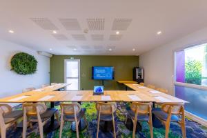 Una sala de conferencias con una gran mesa y sillas de madera. en Hôtel Pont Rouge , Carcassonne, en Carcassonne