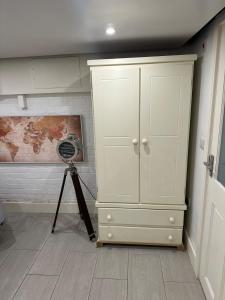 Una habitación con un armario blanco y una cámara. en Sleek Self-Contained Studio Retreat own entrance, en Dorking