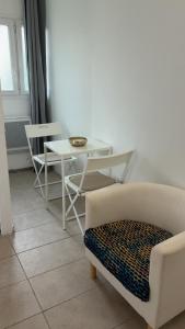 a living room with a table and a chair at Le Nid Chaleureux Ecoresponsable in Sevran