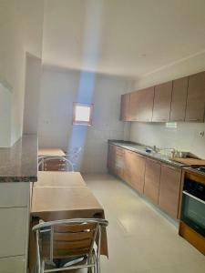 una cucina con mobili in legno, tavolo e sedie di African Guesthouse a Tarrafal