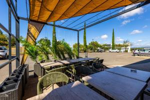 un patio al aire libre con mesas y sillas de madera en Hôtel Pont Rouge , Carcassonne, en Carcassonne