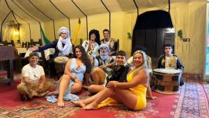 a group of people posing for a picture in a tent at Pulse Desert Camp in Merzouga