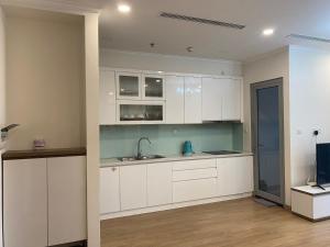 una cucina con mobili bianchi e un lavandino di Vinhomes Gardenia a Hanoi