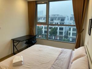una camera da letto con un letto e una grande finestra di Vinhomes Gardenia a Hanoi