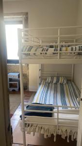 due letti a castello in una stanza con finestra di Casa da Serra a Penhas da Saúde