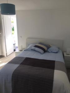 a bedroom with a bed with a black and white blanket at Cosy's'Plage in Kerderff