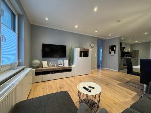 een woonkamer met een bank en een tv bij Ferienwohnung am Glockensee in Bad Laer