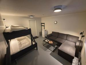 una sala de estar con una cama y un sofá en Camp Mefjord, en Senja