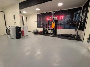Una habitación con gimnasio con un cartel de entrenamiento en la pared. en Camp Mefjord, en Senja