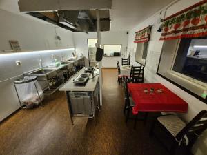 cocina y comedor con mesa roja en Camp Mefjord, en Senja