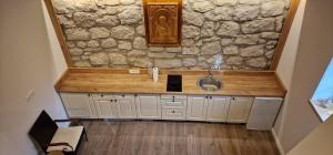 ein Badezimmer mit einem Waschbecken und einer Steinmauer in der Unterkunft Planinska kuća  + 10 Fotos