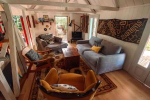a living room with a couch and chairs and a table at L'incroyable maison de Mamie MECHANT in Saint-Philippe