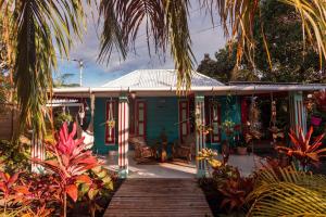 a blue house with a wooden walkway in front of it at L'incroyable maison de Mamie MECHANT in Saint-Philippe +30 photos