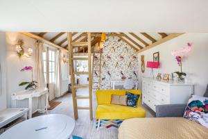 un soggiorno con sedia gialla e tavolo di Tiny House in Wonderland a Henfield