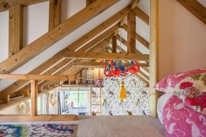 Camera mansardata con letto e travi in legno. di Tiny House in Wonderland a Henfield