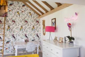 una stanza con una scrivania e una parete ricoperta di carta da parati di Tiny House in Wonderland a Henfield