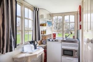 una cucina con lavello, fornello e finestre di Tiny House in Wonderland a Henfield Altre 50 foto