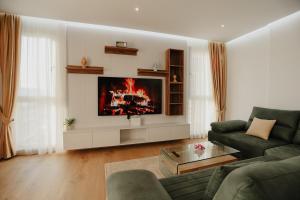 TiraneにあるAri Luxury Apartmentのソファと壁掛けテレビのあるリビングルーム