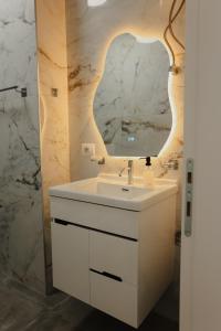 TiraneにあるAri Luxury Apartmentの白い洗面台と鏡のあるバスルーム