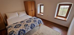 ein Schlafzimmer mit einem Bett und zwei Fenstern in der Unterkunft Planinska kuća 