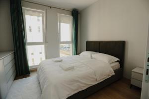 TiraneにあるAri Luxury Apartmentの白いシーツと窓のあるベッドのある寝室