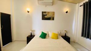 a bedroom with a white bed with yellow and green pillows at Erin Orr Villa in Wadduwa +98 photos