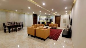 a living room with couches and a table and a kitchen at Peace House II in Islamabad