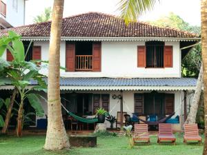a house with chairs and hammocks in front of it at Galawatta Beach Resort in Unawatuna