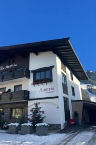 a building with a christmas tree in front of it at Hotel-Garni Austria in Westendorf