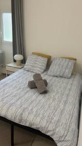 a bed with a stuffed animal on top of it at Le Nid Chaleureux Ecoresponsable in Sevran